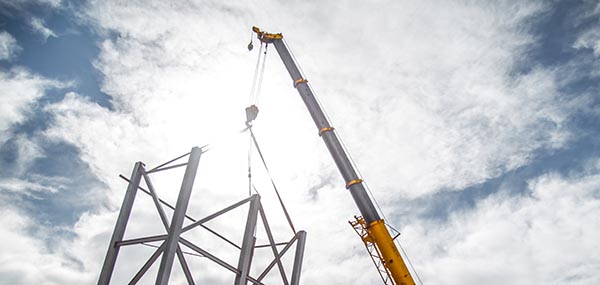 Telescoping crane boom extended against a blue sky